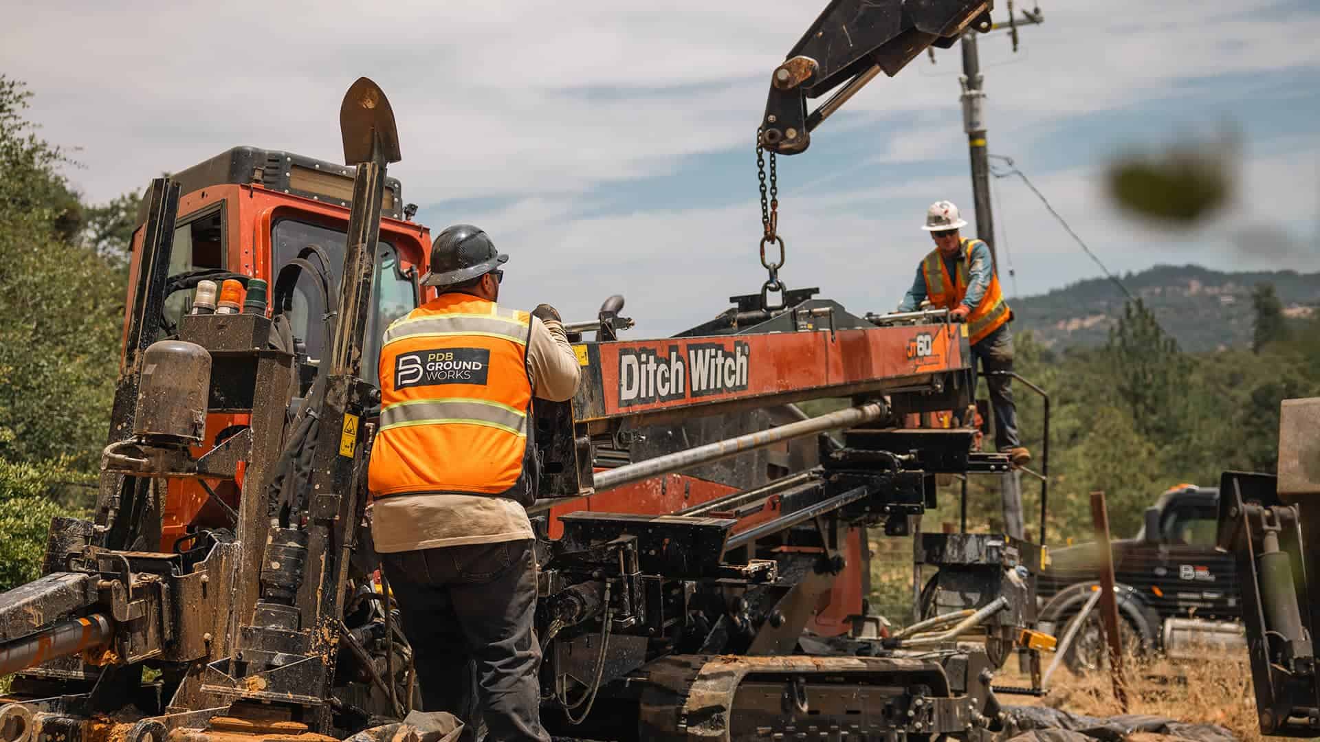 A team of construction workers actively engaged in building activities at a busy construction site with machinery around.