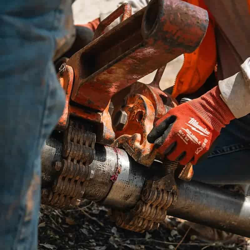 A man repairs a pipe.